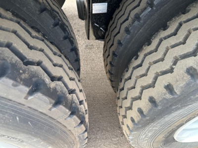 Dual rear tires of a new Smithco air ride side dump trailer showing heavy tread and gap between tires.