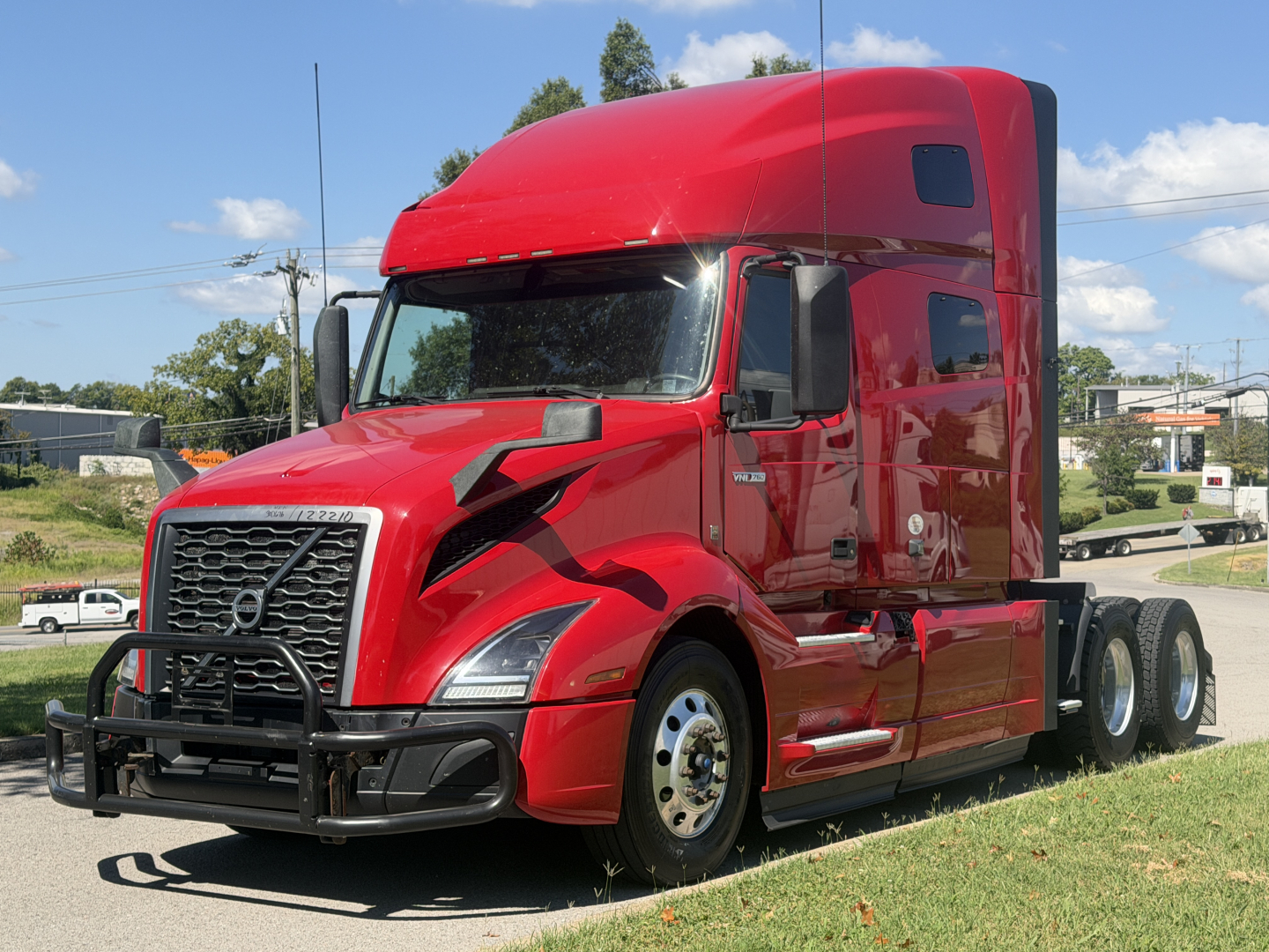 Volvo VNL64T760 truck in red cab viewed from front-left showing sleeper and dual rear axles.