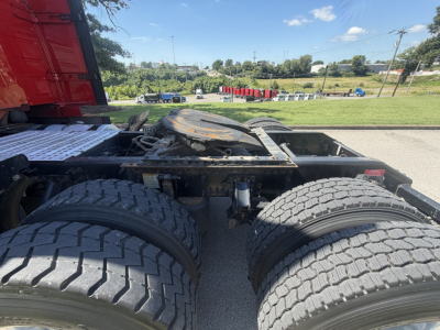Truck chassis showing dual rear axles and fifth wheel on a Volvo VNL64T760, with visible tires and air lines.