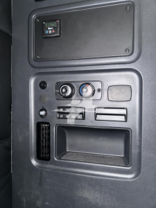 Dashboard panel with control knobs and vents; no legible labels visible