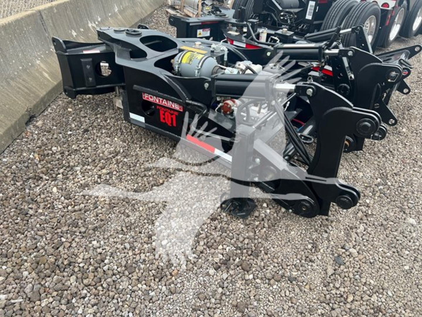 Fontaine 55Mx lowboy trailer hitch assembly with hydraulic cylinder and handling arms visible; close-up of chromed joints and mounting plate.