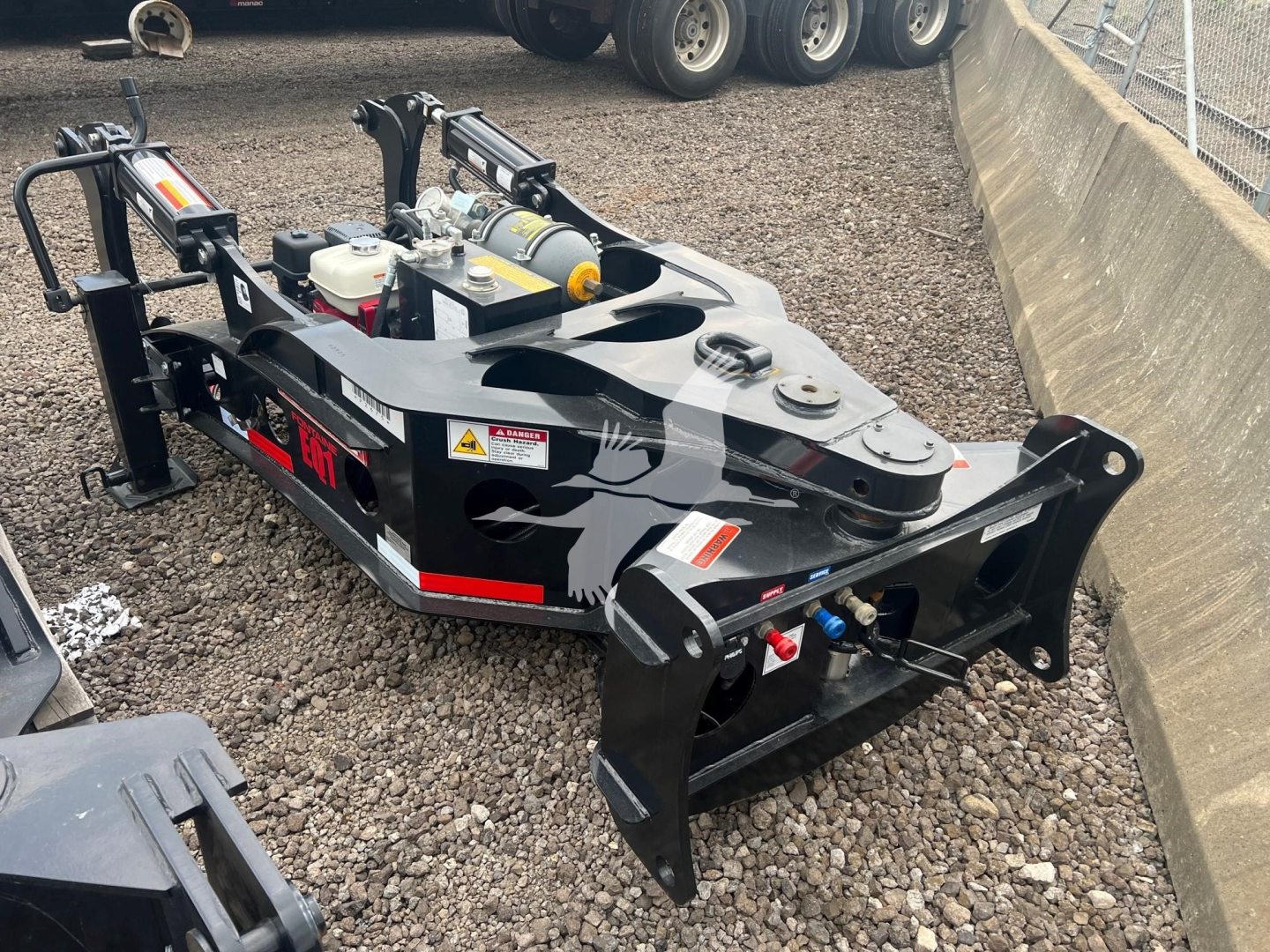 Fontaine EQ-1 lowboy trailer with hydraulic unit and front hitch, visible warning labels, hydraulic hoses, and black framing. Text on side reads Fontaine or EQ-1 components; visible stickers and safety decals.