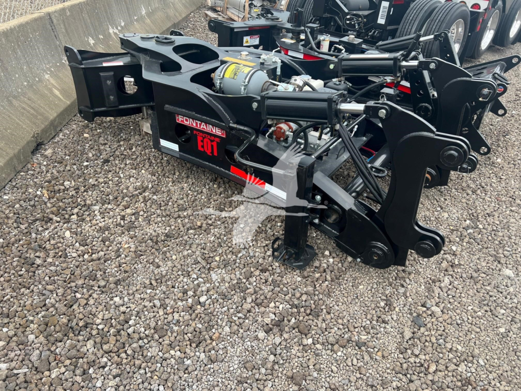 Fontaine EQT lowboy trailer hitch assembly showing hydraulic actuator and label reading Fontaine EQT in red and black with chains and mounting brackets.