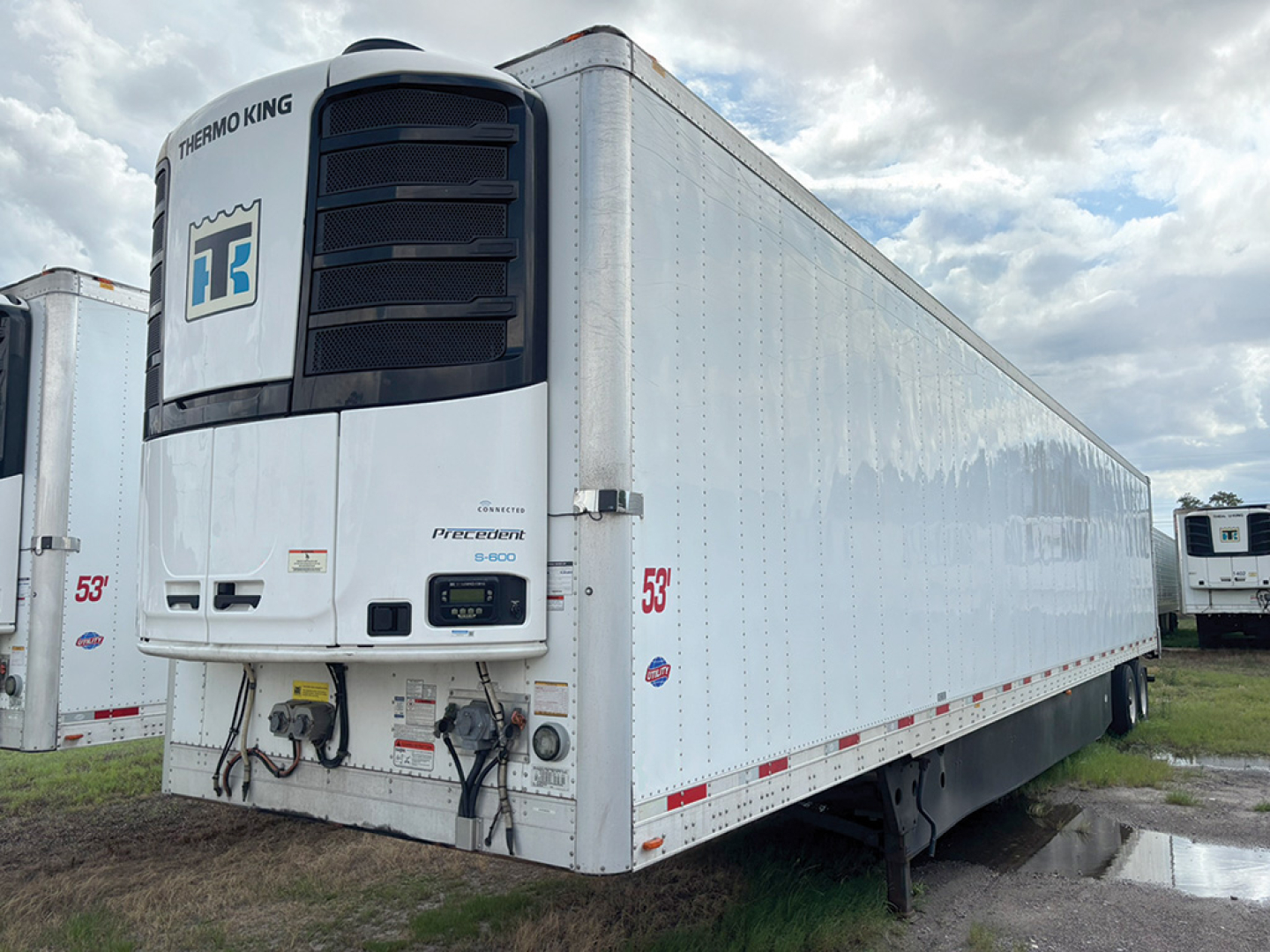 Thermo King trailer reefer with white aluminum body and black front cooling unit, 53' length, side red and white reflective decals.