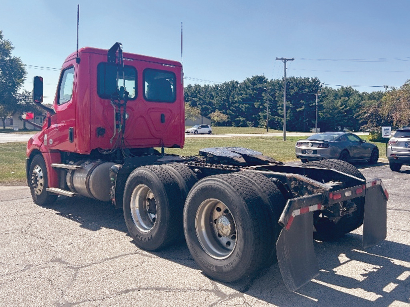 Truck chassis and cab of a 2019 Freightliner Cascadia126 in view from left-rear showing the tractor, rear dual axles, and mud flaps.