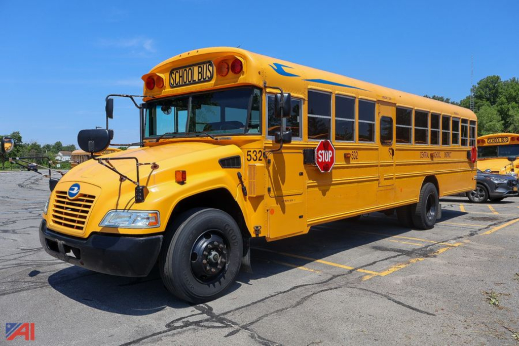 Yellow 2018 Blue Bird Vision school bus parked in a lot showing front and side views with Stop sign and school bus text