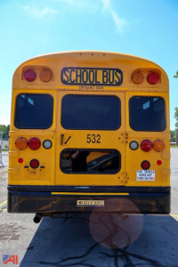 Bus rear showing school bus signage, lights, and emergency door, with number 532 and Blue Bird badge.
