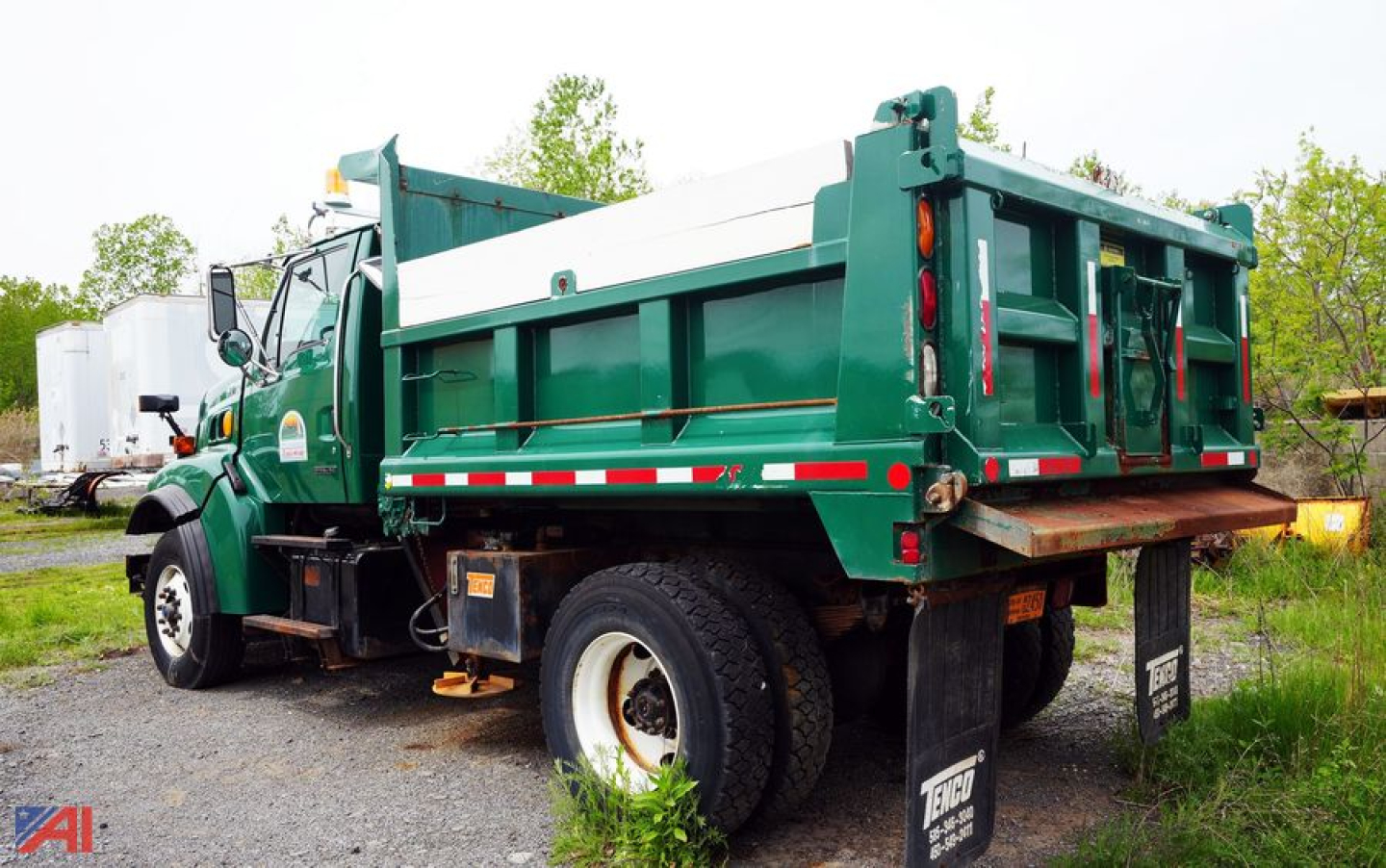 Dump truck bed with green Sterling L9500 style dump body and wing, side view showing rear rails and mud flaps.