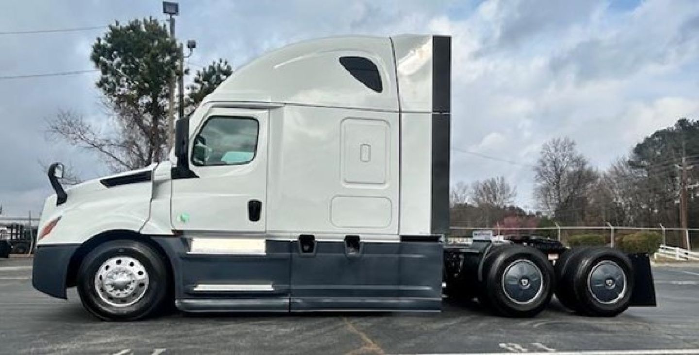 Freightliner Cascadia 126 sleeper tractor side view showing 6x4 axle, white cab, gray lower body, air intake, and wheels