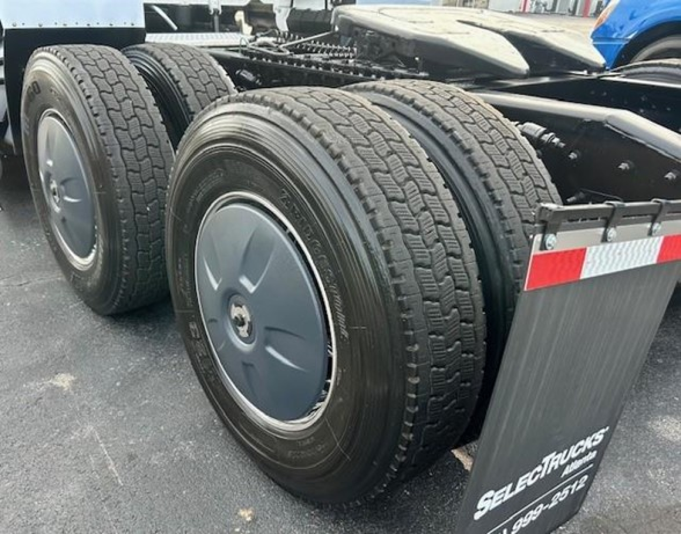 Trucks axle rear view showing dual rear tires and wheel covers on Freightliner Cascadia chassis.