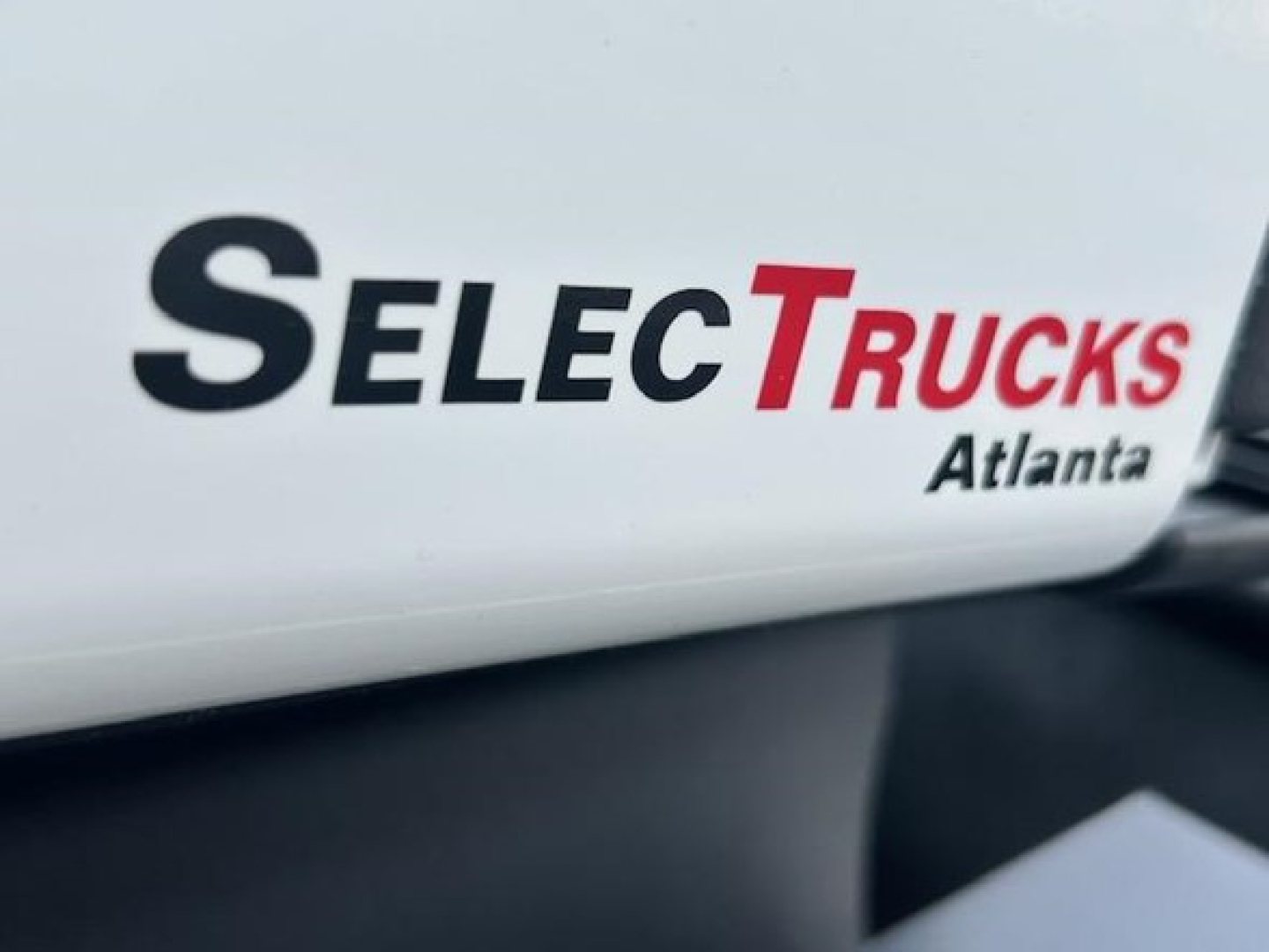 View of a white truck cab with SelecTrucks Atlanta logo and partial text.