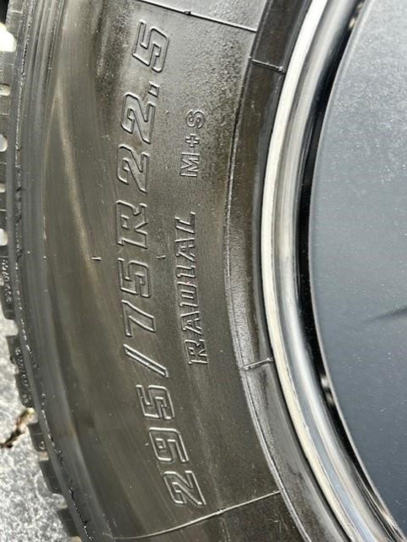 Tire sidewall showing size 295/75R22.5 and other markings: R1A2AXL, 3969? M+S. Close-up view of wheel and tire.