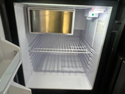 Freightliner Cascadia 126 cab interior showing empty refrigerator-like freezer compartment with shelves and a small control panel.