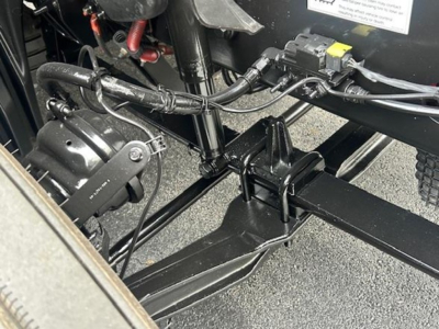 Freightliner Cascadia chassis area showing electrical harnesses and frame components under cab with wiring and connectors.