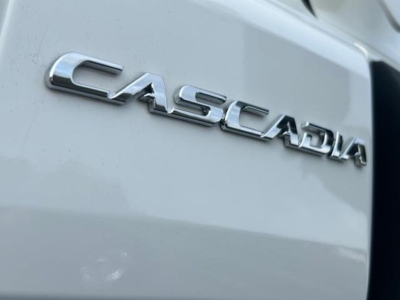 Casadia badge on a Freightliner Cascadia truck showing the 'CASCADIA' chrome emblem on a light-colored exterior.