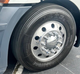 Front wheel of a Freightliner Cascadia 126 showing a large heavy-duty tire with steel hub and lug nuts; Rim reads Bridgestone tire model R235/70R22.5 and Wheel Hub visible.