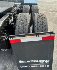 Truck rear view showing dual rear axles and mudguard with SelectTrucks Atlanta logo and contact number.