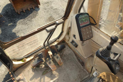 Interior cab view of a 1993 Caterpillar 312 excavator showing pedal cluster, joystick, and operator console with display.