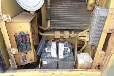 Caterpillar 312 excavator engine bay showing battery and electrical components