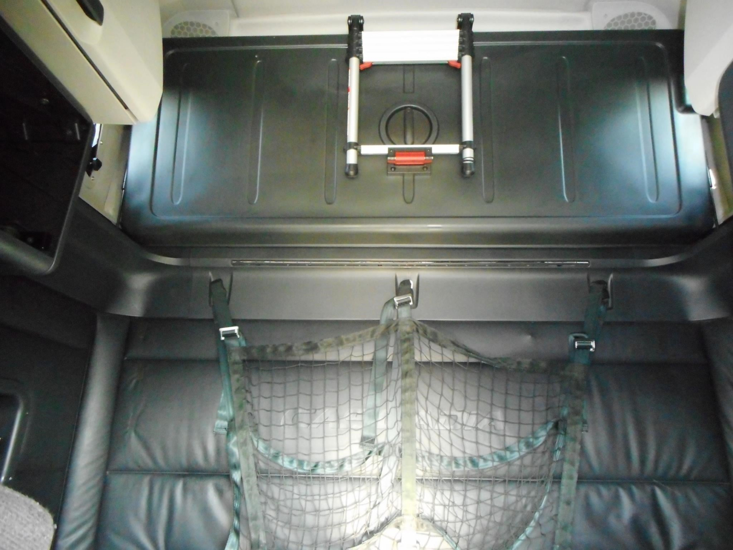Freightliner Cascadia 126 cab interior showing overhead bunk storage and cargo net.