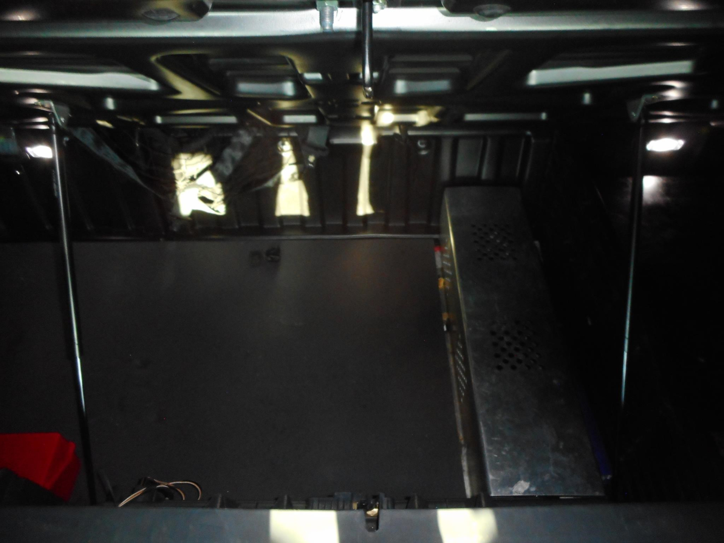Freightliner Cascadia cab interior with under-dash components and exposed metal framework.