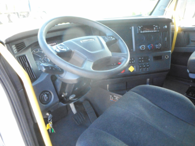 Cab interior of a Freightliner Cascadia 126 truck showing steering wheel, dashboard, and driver seat area.