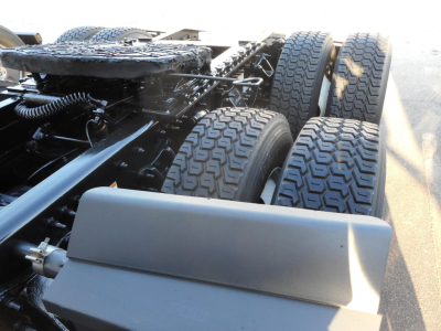Truck chassis showing dual rear axles and tires on a Freightliner Cascadia 126 with visible frame and drivetrain components