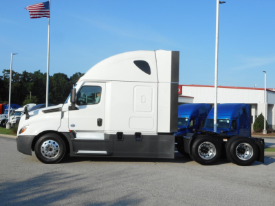 2024 Freightliner Cascadia 126 side view showing sleeper cab with tandem rear axles and white cab.