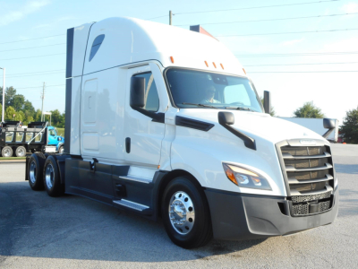 Truck cab showing 2024 Freightliner Cascadia 126 sleeper with white paint, black grille, and side mirrors; front right view.