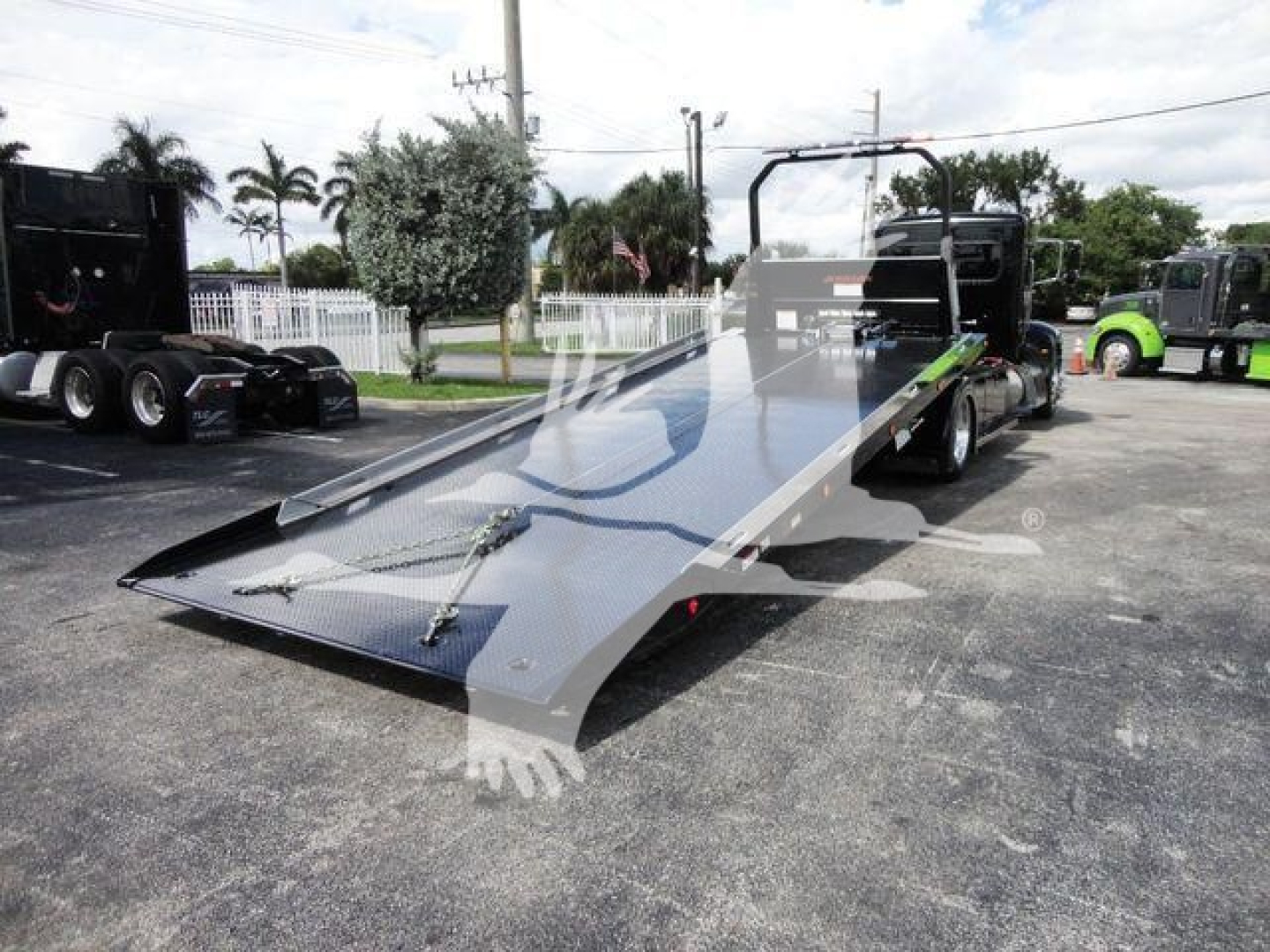 Truck equipment: 2022 Peterbilt 337 rollback flatbed with hydraulic ramp, low-angle loading deck, steel surface, dual rear wheels visible.