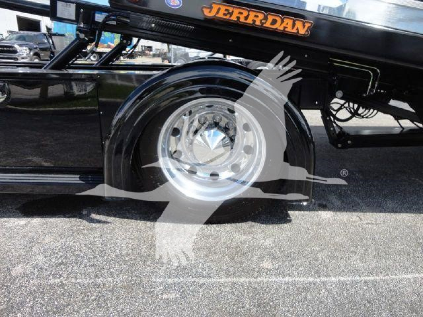 Truck wheel and suspension area of a 2022 Peterbilt 337 rollback chassis showing chrome wheel hub and black frame with JERRRDAN branding.