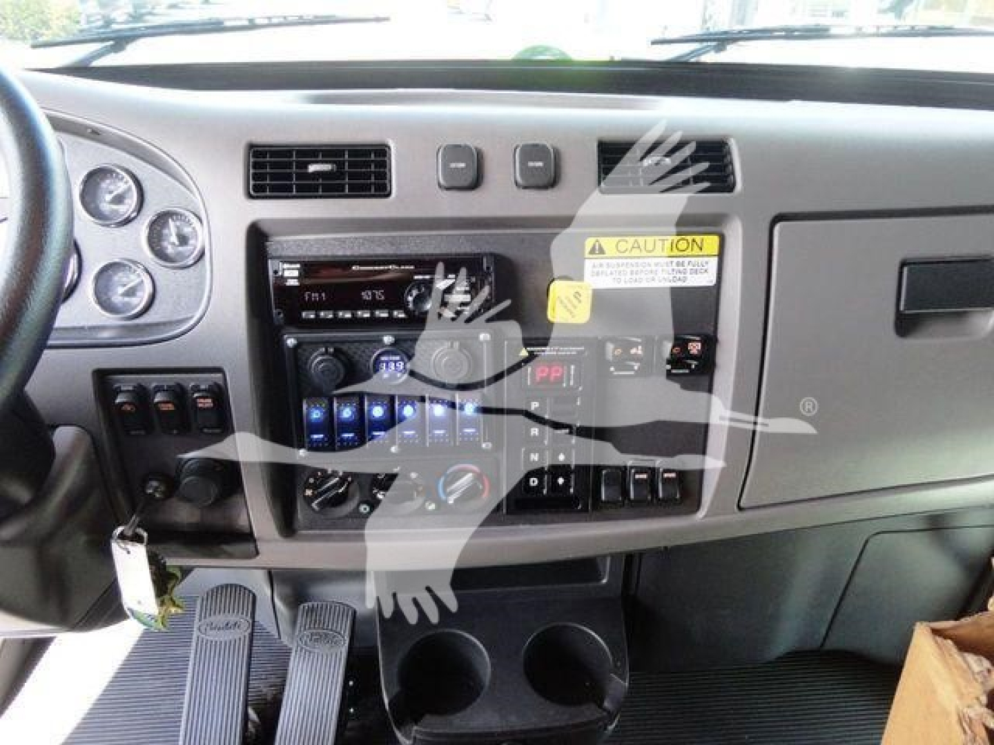 Peterbilt 337 dashboard and center console showing gauges, climate controls, and ignition with keys in.