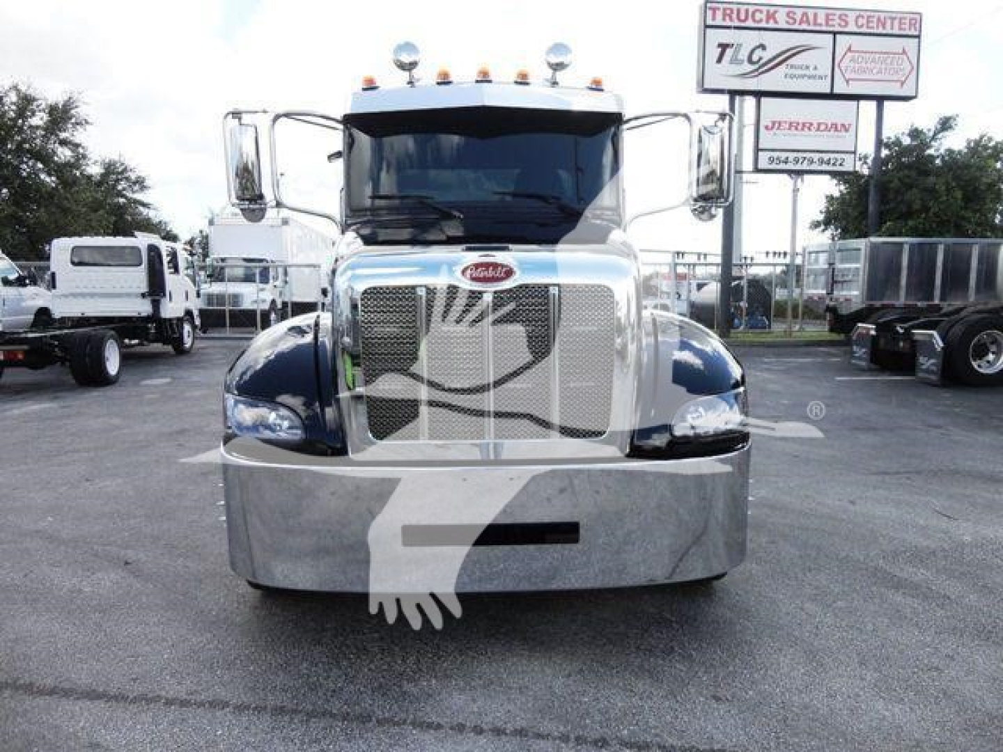 Peterbilt 337 truck front view with chrome grille and bumper in a dealership lot.