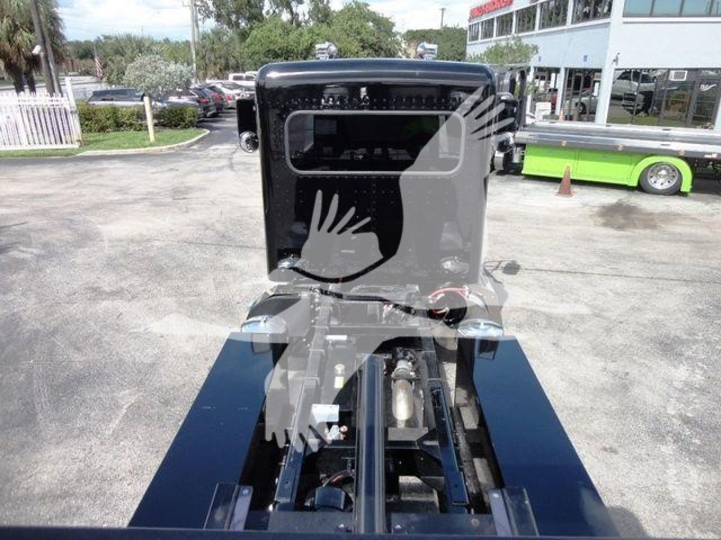 Peterbilt 337 truck chassis view showing roll-back bed mounting points and cab in background.