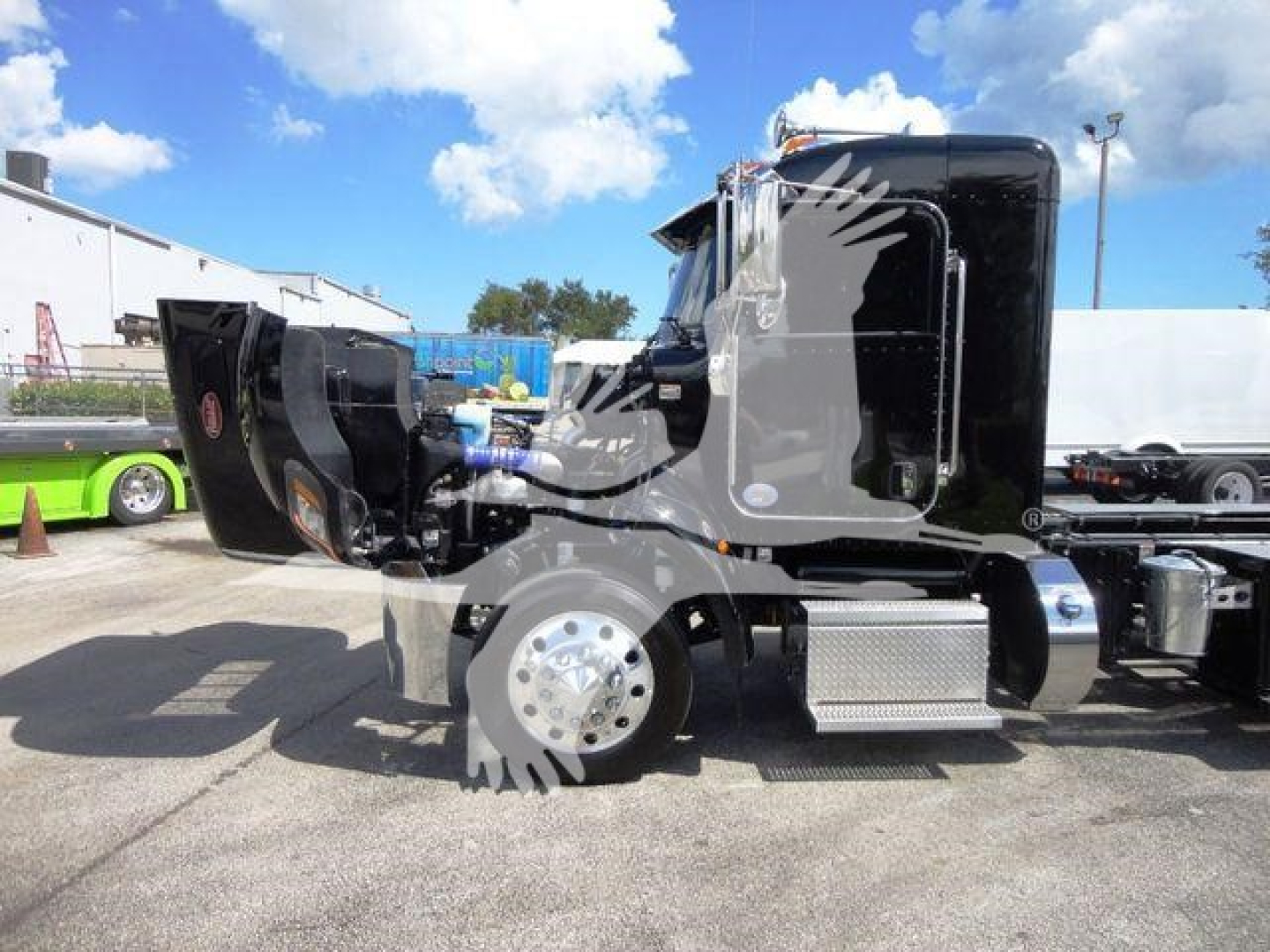 Peterbilt 337 cab in rollback configuration with hood open, showcasing side step, fuel tank, and chassis components.