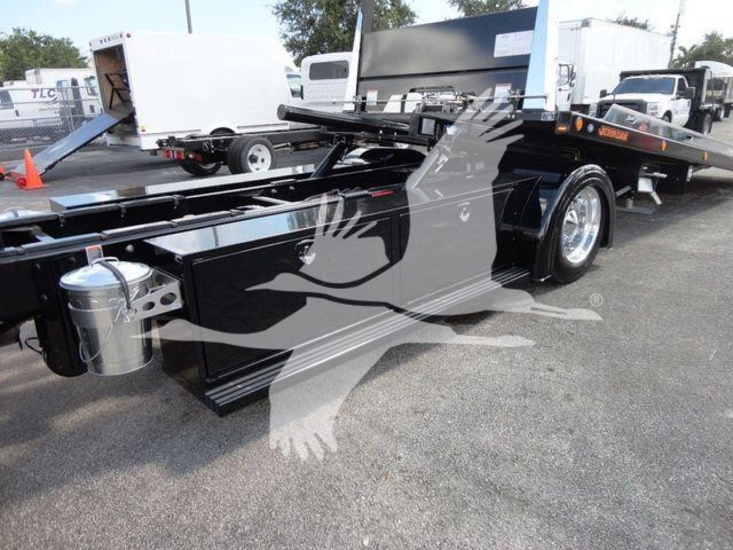 Peterbilt 337 rollback truck showing flatbed body with hydraulic tilt mechanism and dual rear axles, side view featuring chrome fuel tank and toolbox.