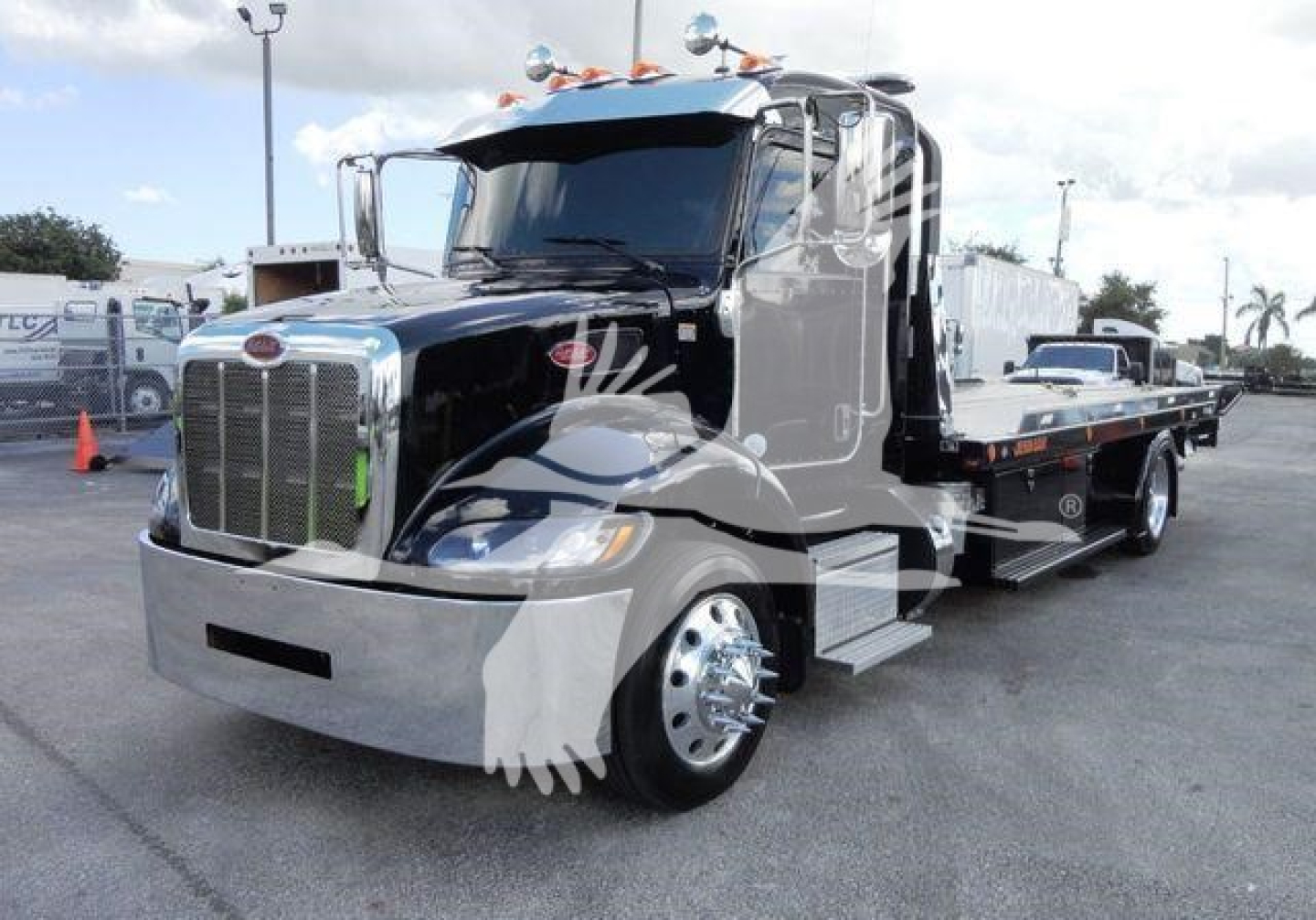 Peterbilt 337 rollback truck in black with chrome front, side view, showing flatbed tilt bed and dual rear wheels.