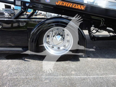 Truck wheel and suspension area of a 2022 Peterbilt 337 rollback chassis showing chrome wheel hub and black frame with JERRRDAN branding.