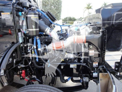 Peterbilt 337 truck engine bay with exposed components and hoses, wiring harnesses, and filters visible.