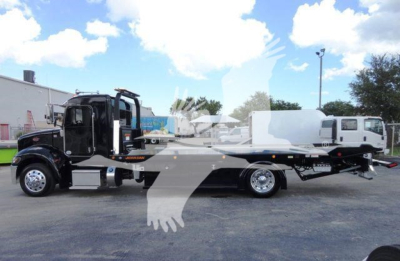 Peterbilt 337 rollback tow truck side view showing flatbed with wheel lift and dual rear axles