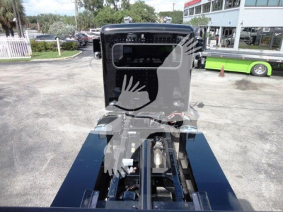 Peterbilt 337 truck chassis view showing roll-back bed mounting points and cab in background.