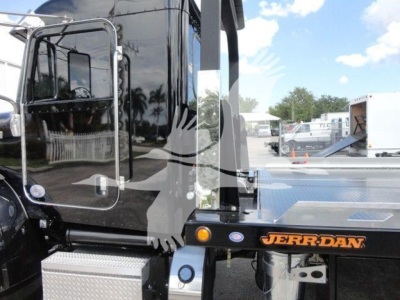 Peterbilt 337 rollback truck side view showing JERR-DAN equipment and cab door with reflective surface.
