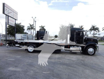 Peterbilt 337 rollback tow truck side view showing lowboy hauler bed and black cab.