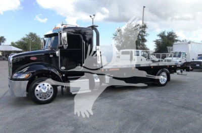 Peterbilt 337 rollback wrecker truck in black, side view showing cab and long bed with chrome wheels.