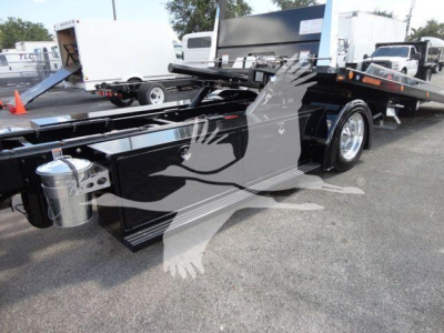 Peterbilt 337 rollback truck showing flatbed body with hydraulic tilt mechanism and dual rear axles, side view featuring chrome fuel tank and toolbox.