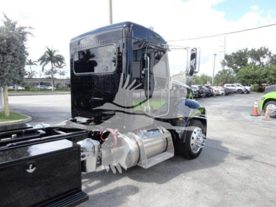 Peterbilt 337 rollback truck cab and fuel tank visible from rear-side angle with chrome fuel tank and black body.