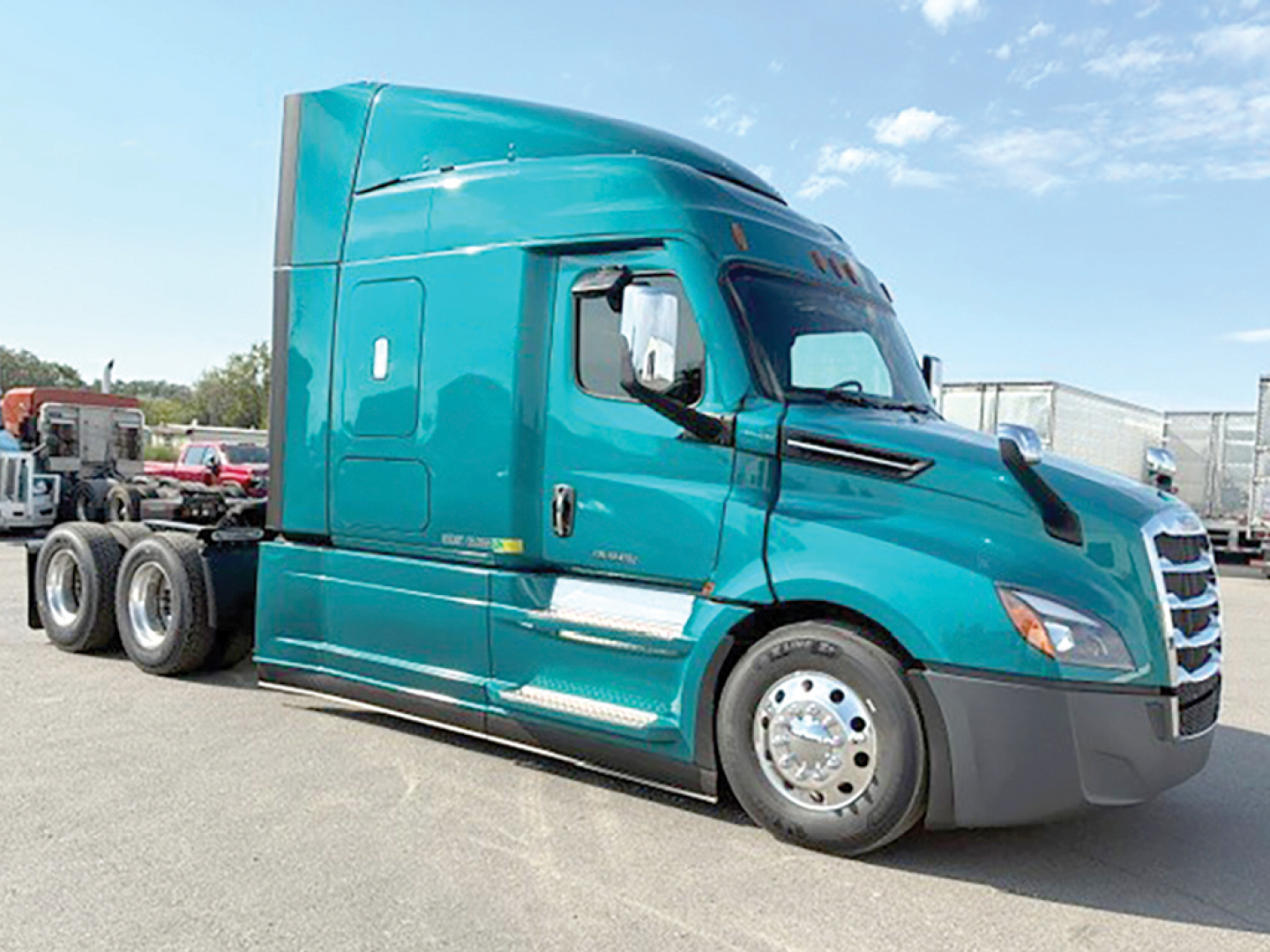 Truck cab side view showing teal Freightliner Cascadia126 sleeper with chrome wheels and tandem rear axles.