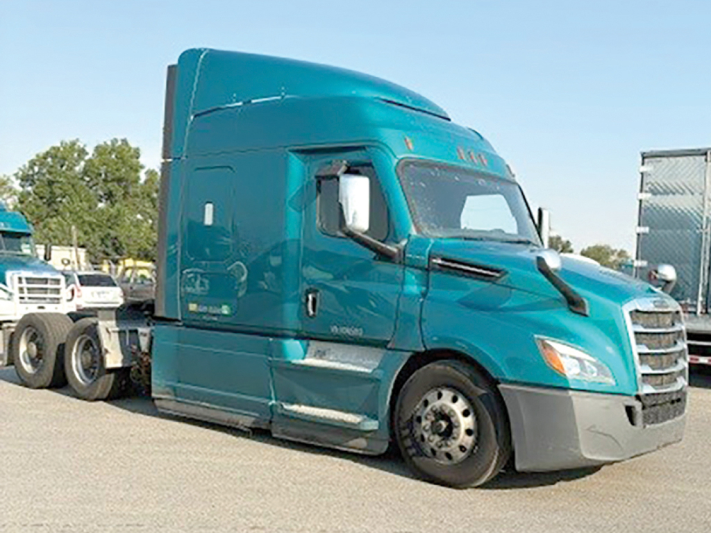 Truck front side view showing turquoise Freightliner Cascadia126 sleeper with aerodynamic hood and detached wheel at front, no visible text