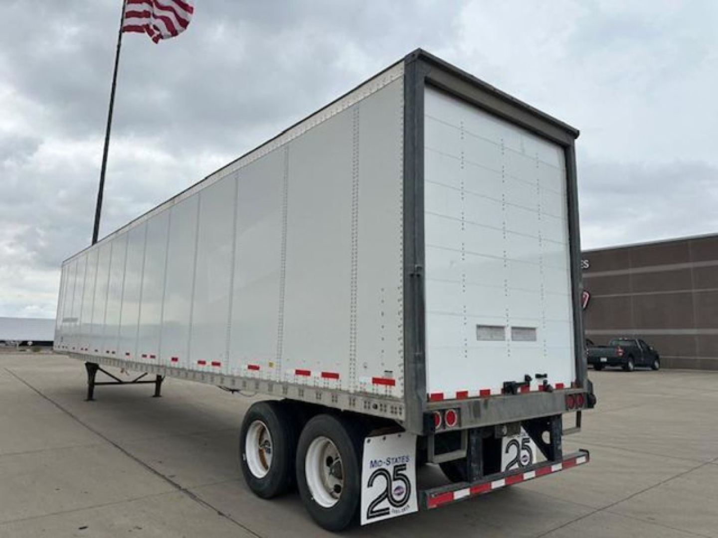 Trailers side and rear view of a 2014 Wabash box trailer with tandem axles and a rear roll-up door.