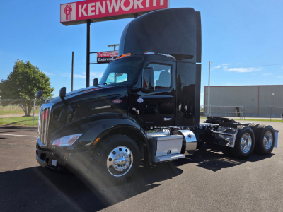 2022 Peterbilt 579 conventional daycab truck in black, side view, with tall sleeper cab, chrome fuel tanks, dual rear wheels, and Peterbilt badge visible.